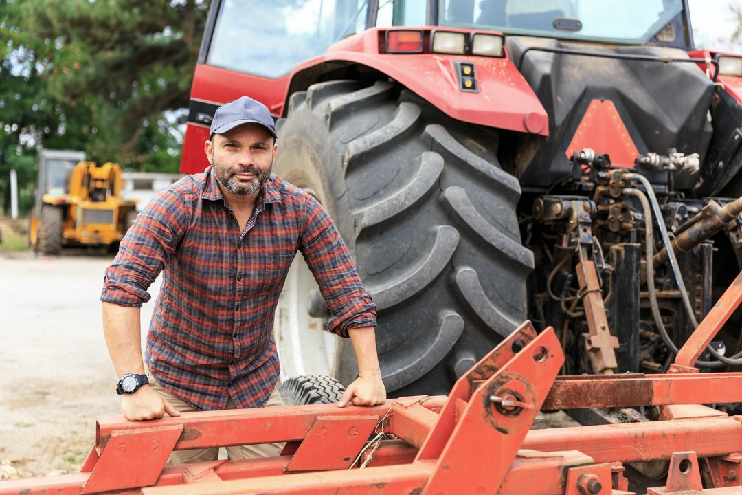 farmer stojący przy ciągniku